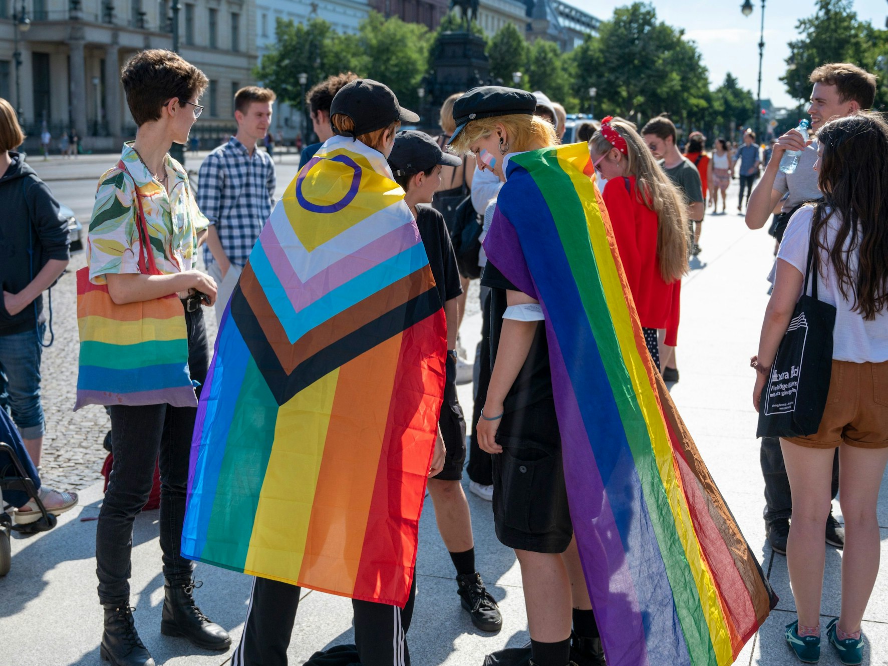 Mehrere Personen mit Regenbogenfahnen.