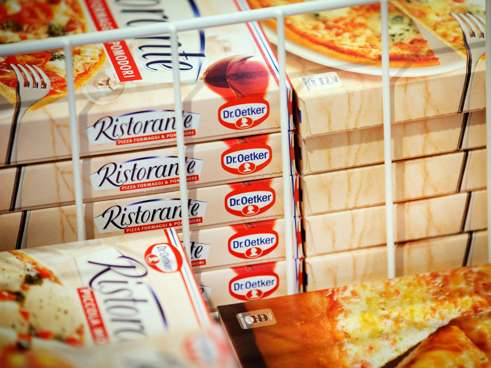 Mehrere Boxen mit Tiefkühlpizzen der Marke Dr. Oetker stapeln sich in einem Tiefkühlregal.