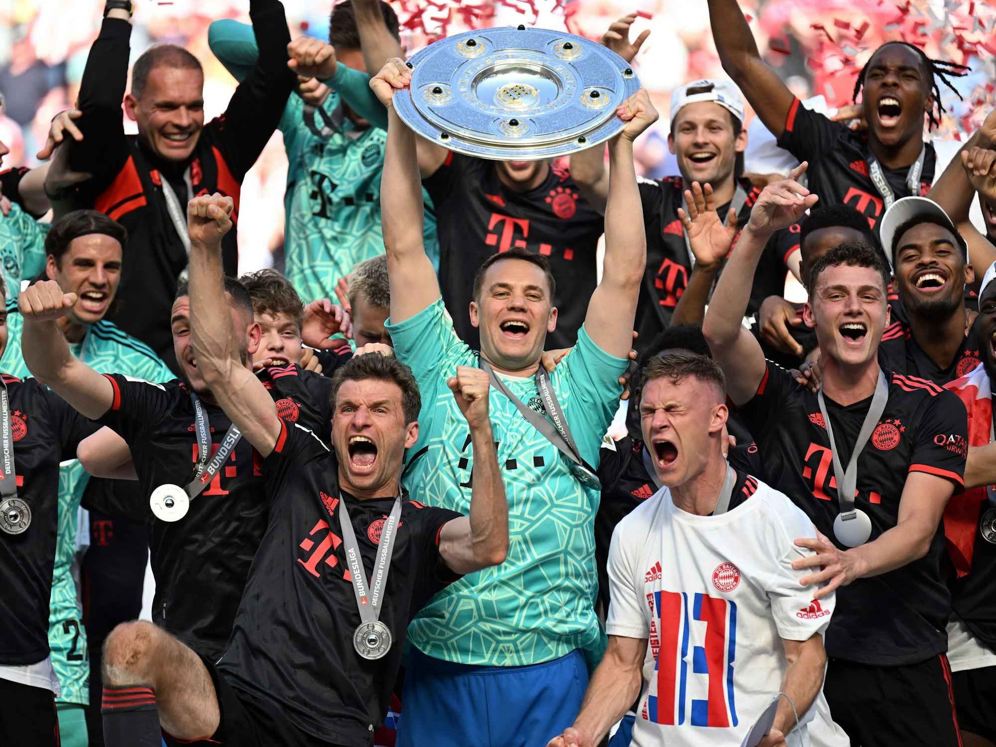 Bayerns Torhüter Manuel Neuer hält die Meisterschale, während seine Teamkollegen nach dem Gewinn der 33. deutschen Meisterschaft jubeln.
