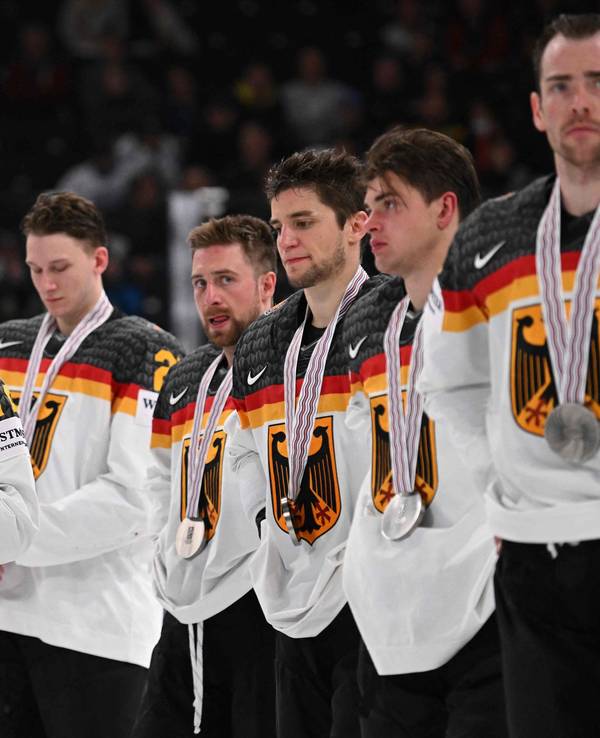 Die deutschen Spieler stehen in einer Reihe. Dominik Kahun küsst seine Medaille.