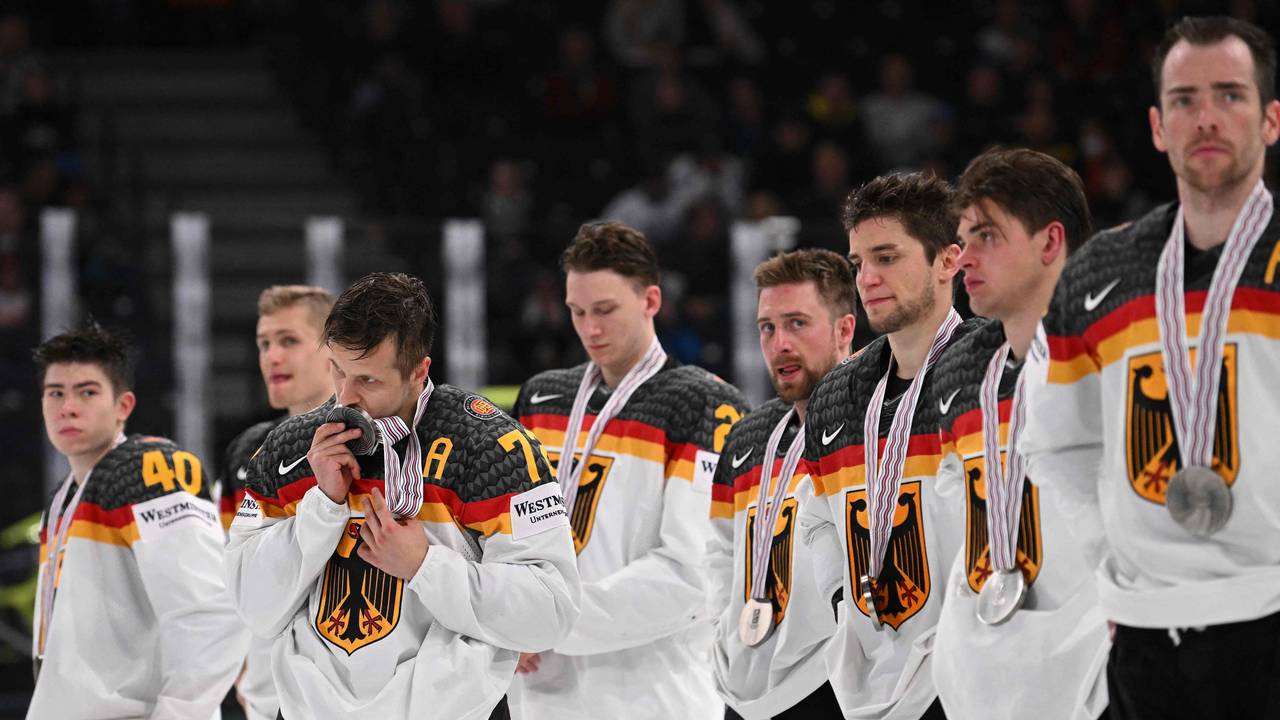 Die deutschen Spieler stehen in einer Reihe. Dominik Kahun küsst seine Medaille.