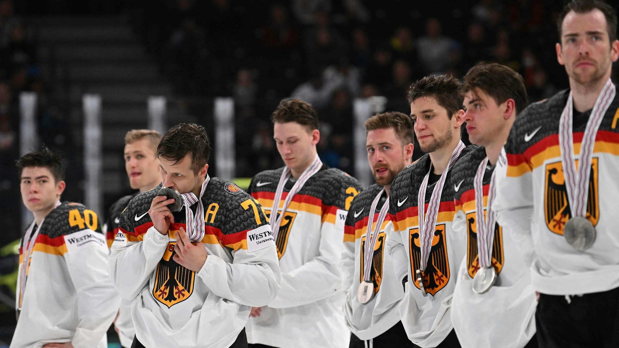 Die deutschen Spieler stehen in einer Reihe. Dominik Kahun küsst seine Medaille.