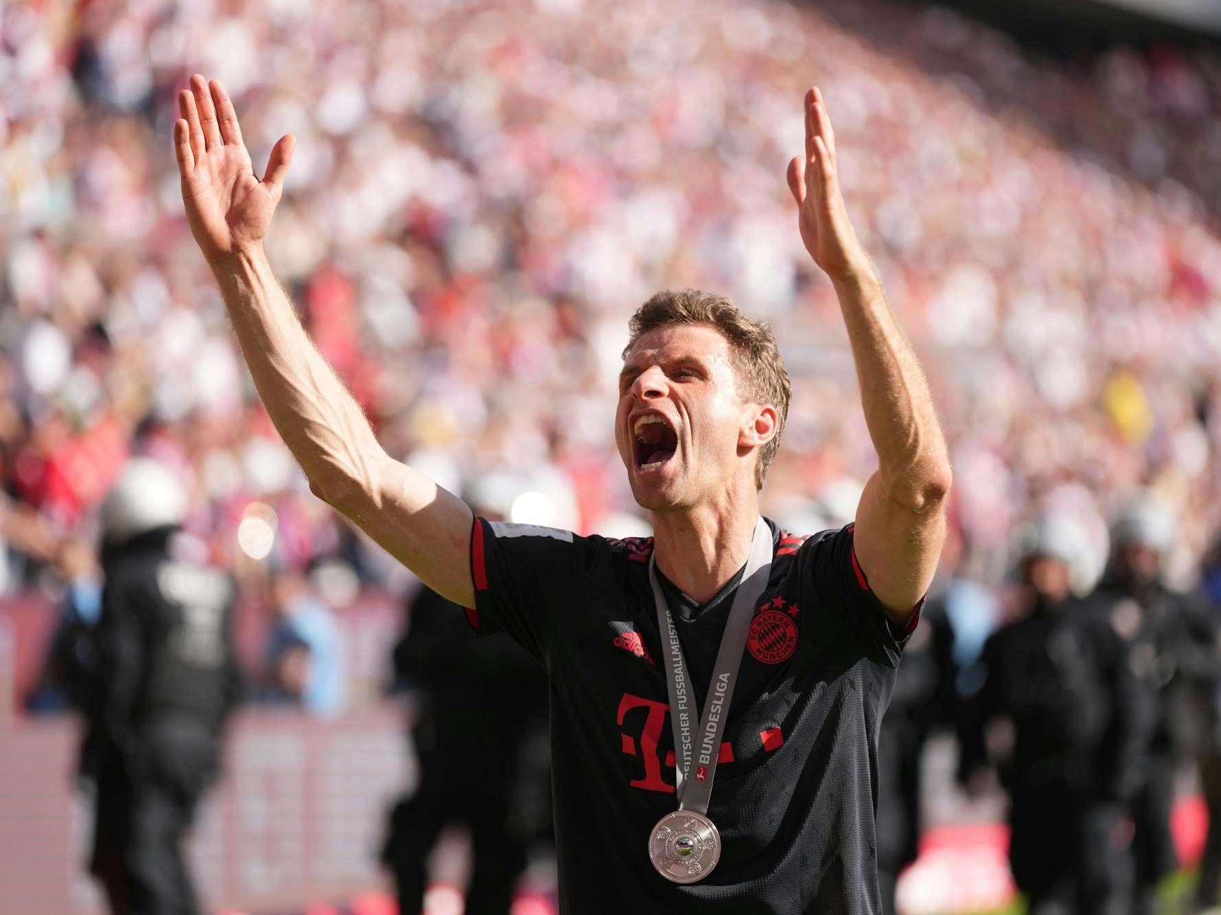 Thomas Müller feiert mit den Bayern-Fans.