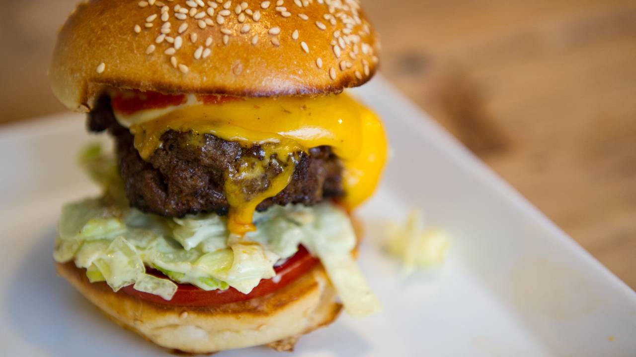 Ein Cheeseburger auf einem Teller.