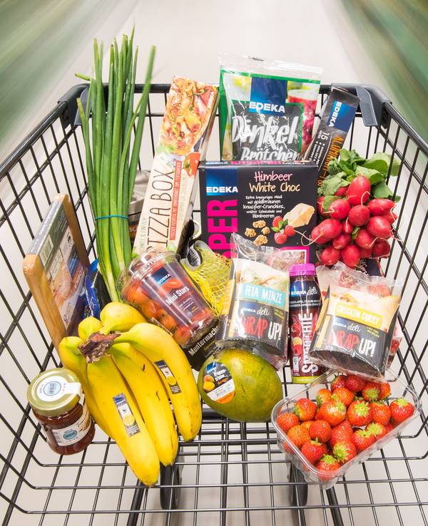Ein Einkaufswagen mit Edeka-Produkten wird durch einen Supermarkt geschoben
