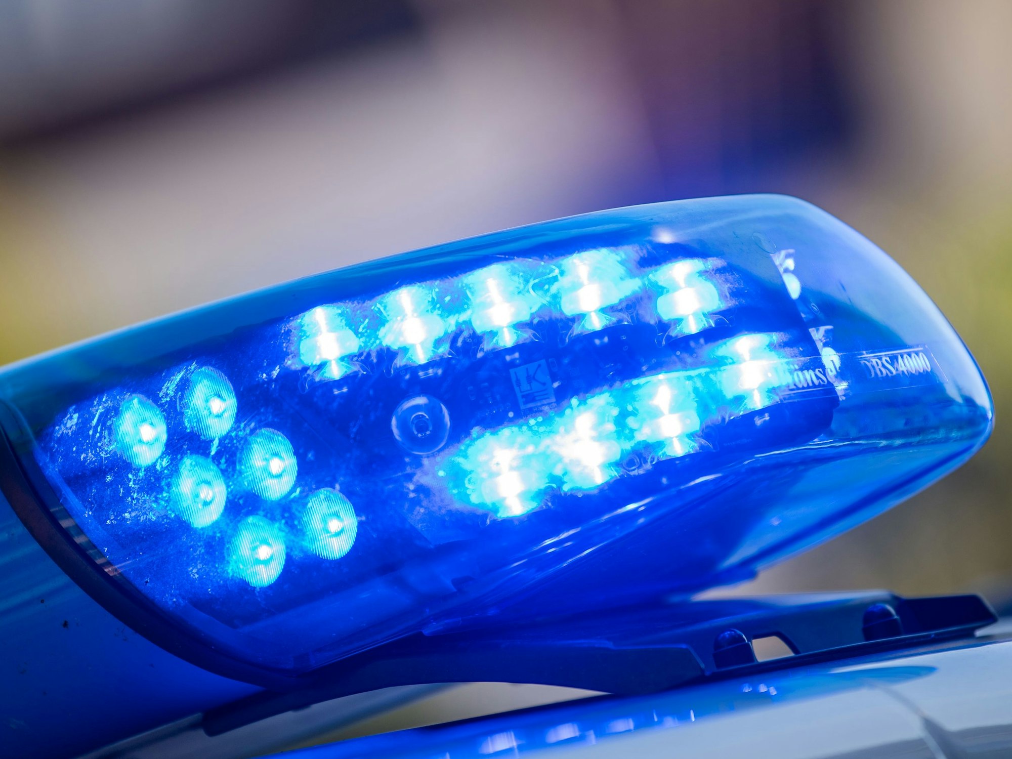 Ein Blaulicht ist auf dem Dach eines Polizeifahrzeugs zu sehen.