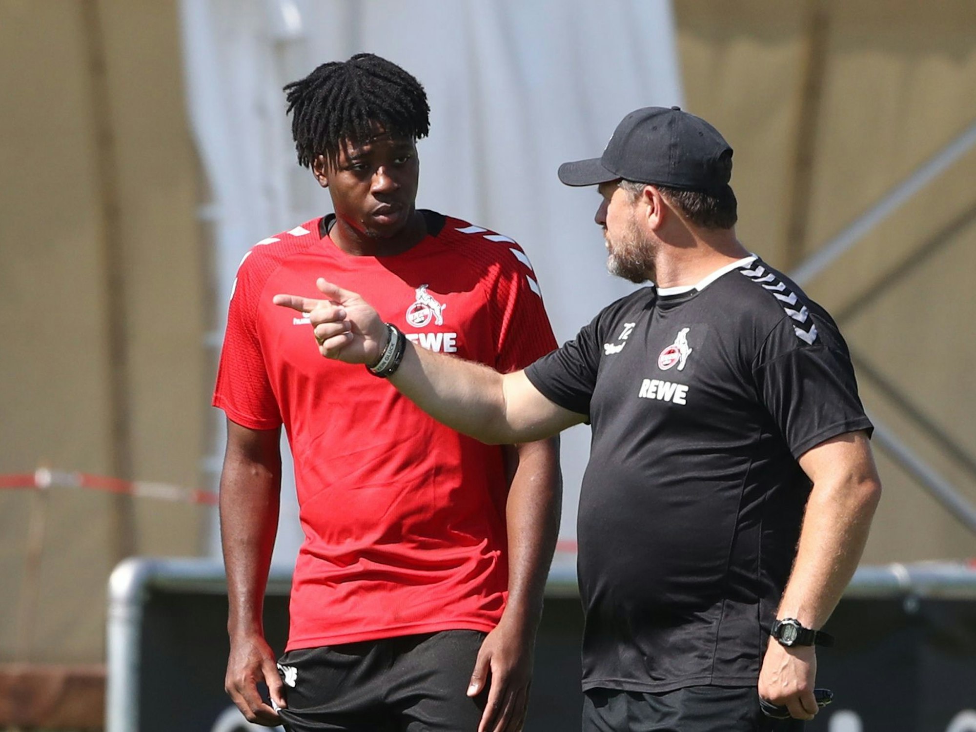 Steffen Baumgart spricht im Training mit Bright Arrey-Mbi.