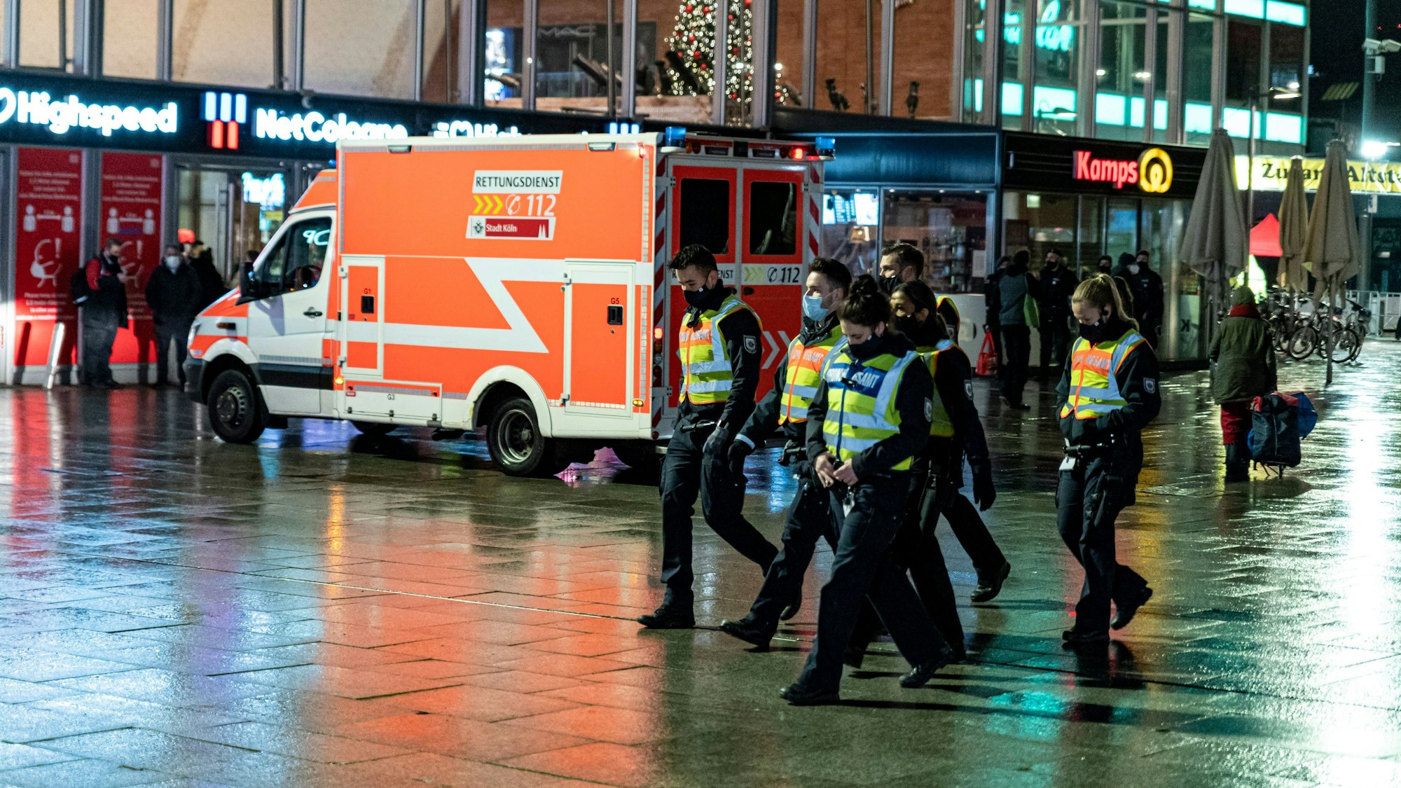 Polizei und Rettungswagen am Dom-Eingang des Kölner Hauptbahnhofs in der Dunkelheit.