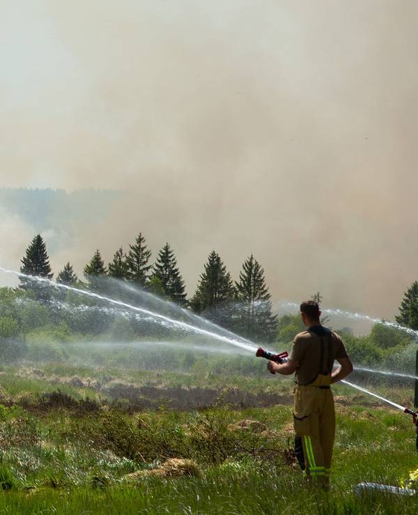 Die Feuerwehr versucht mit einem Hubschrauber einen Moorbrand im deutsch-belgischen Grenzgebiet bei Aachen zu löschen. Das Feuer sei auf belgischer Seite im Hohen Venn ausgebrochen, teilte am 30. Mai 2023 die Städteregion Aachen mit.