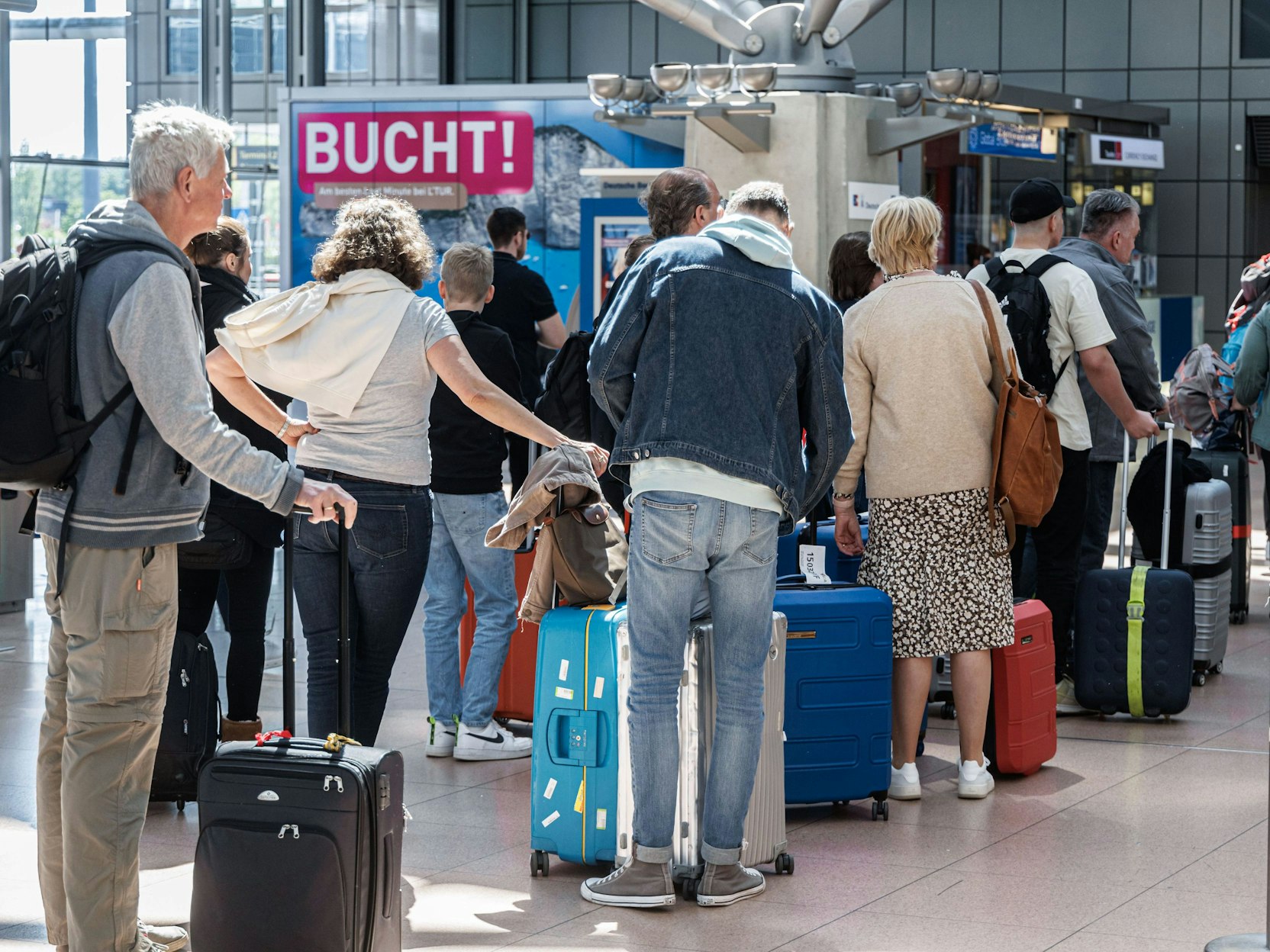Fluggäste stauen sich mit ihrem Gepäck an Check-In-Schaltern.