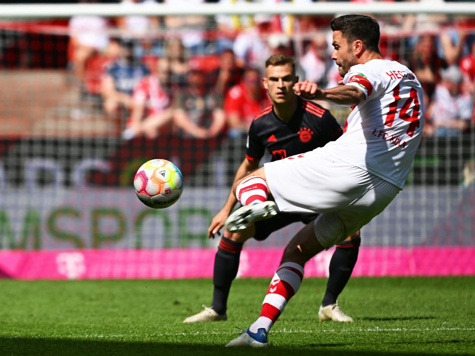 Kölns Jonas Hector (l.) schießt den Ball beim Spiel gegen den FC Bayern München.