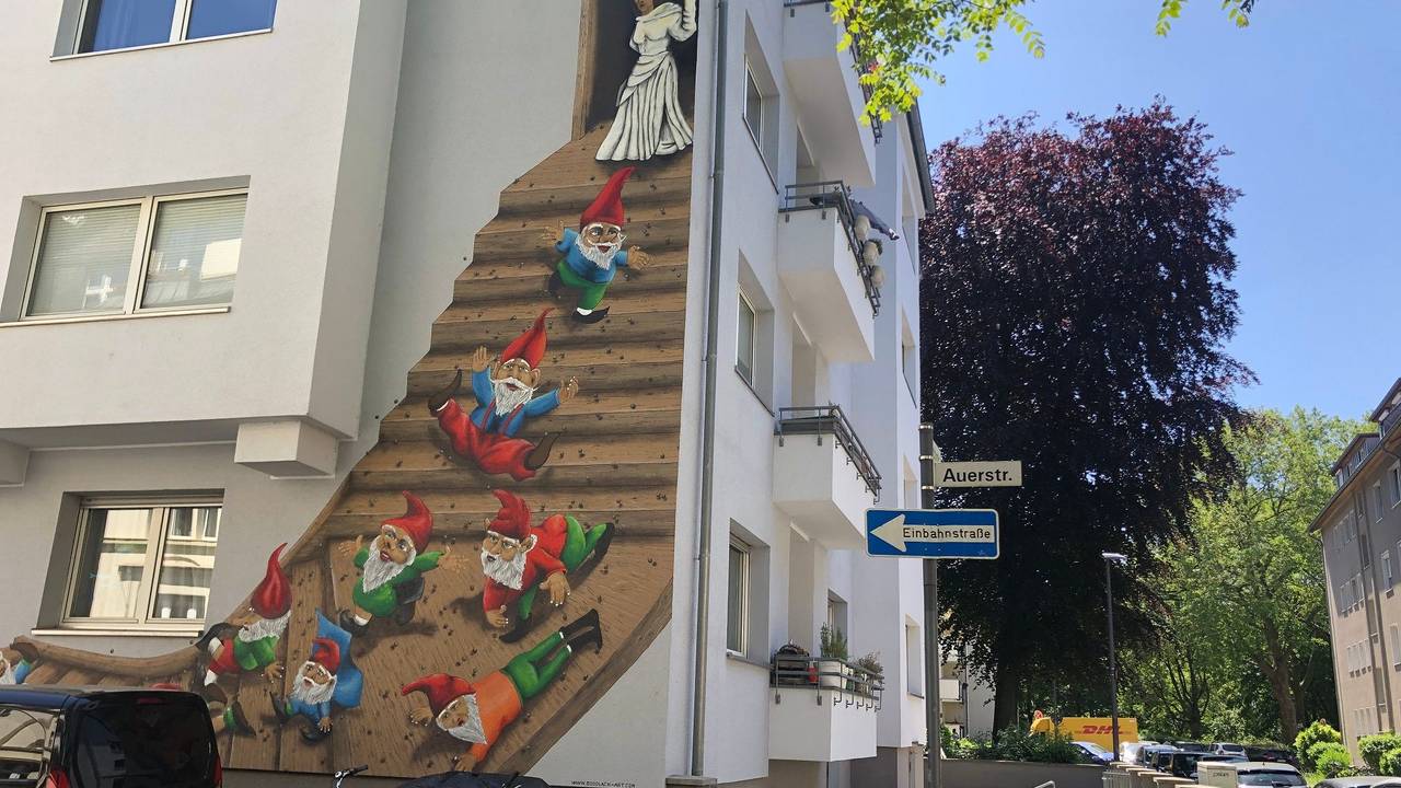 Ein Graffiti-Kunstwerk mit Heinzelmännchen ziert eine Hausfassade in Köln-Nippes.