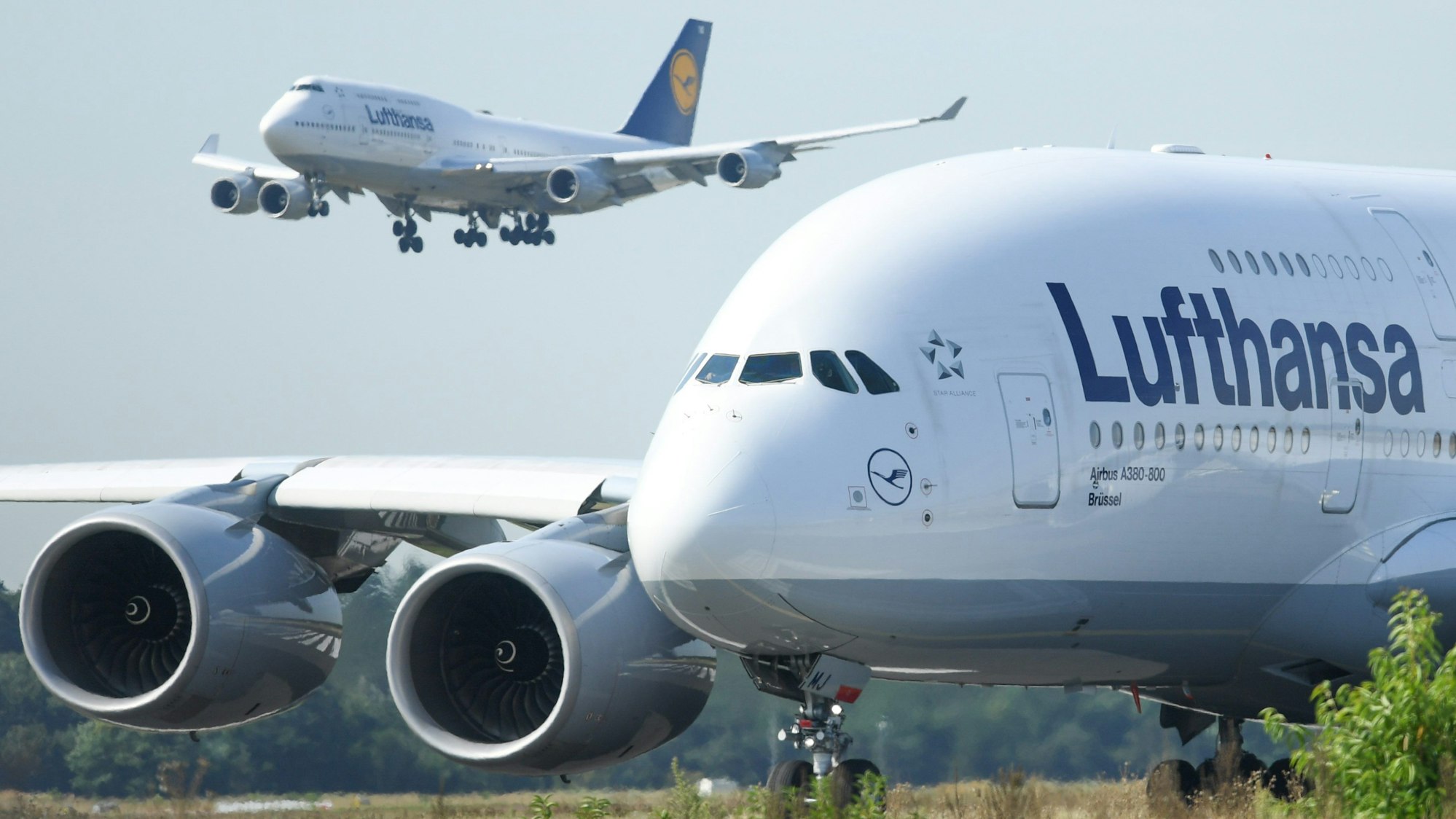 Eine Boeing 747-400 der Lufthansa landet am Flughafen von Frankfurt am Main hinter einem startbereiten Airbus A380-800.