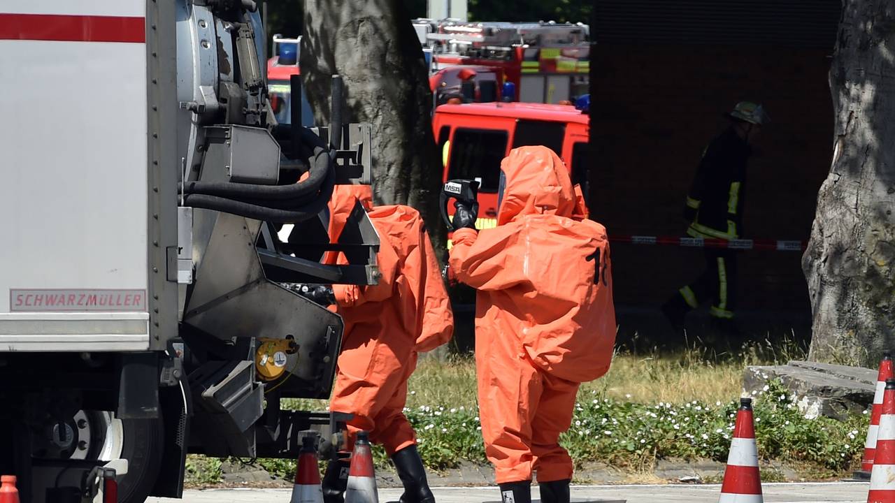 Feuerwehrleute in ABC Schutzanzügen kontrollieren einen Gefahrguttransporter