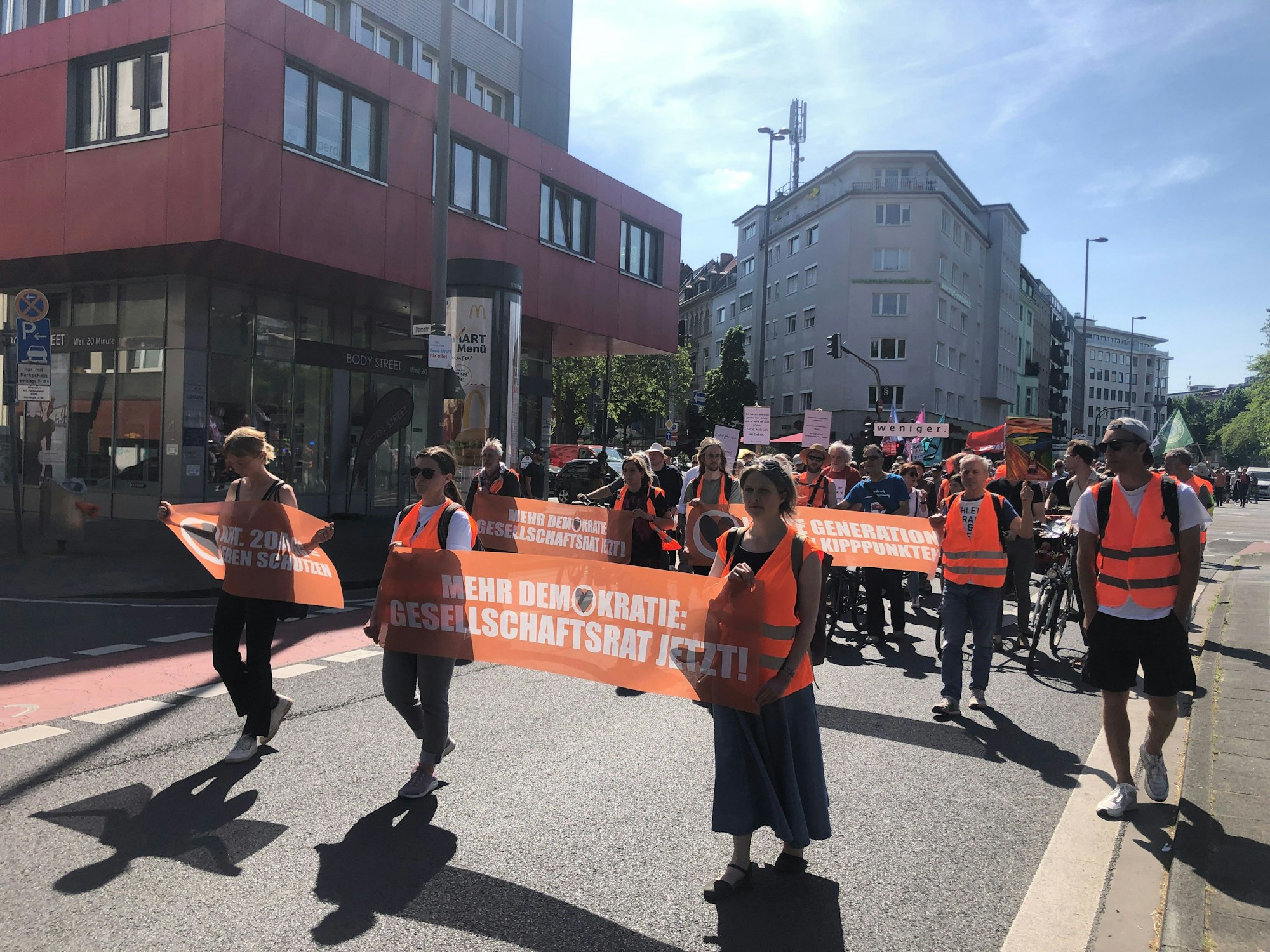 Klimaaktivisten und Aktivistinnen laufen im Protestmarsch in Köln mit.
