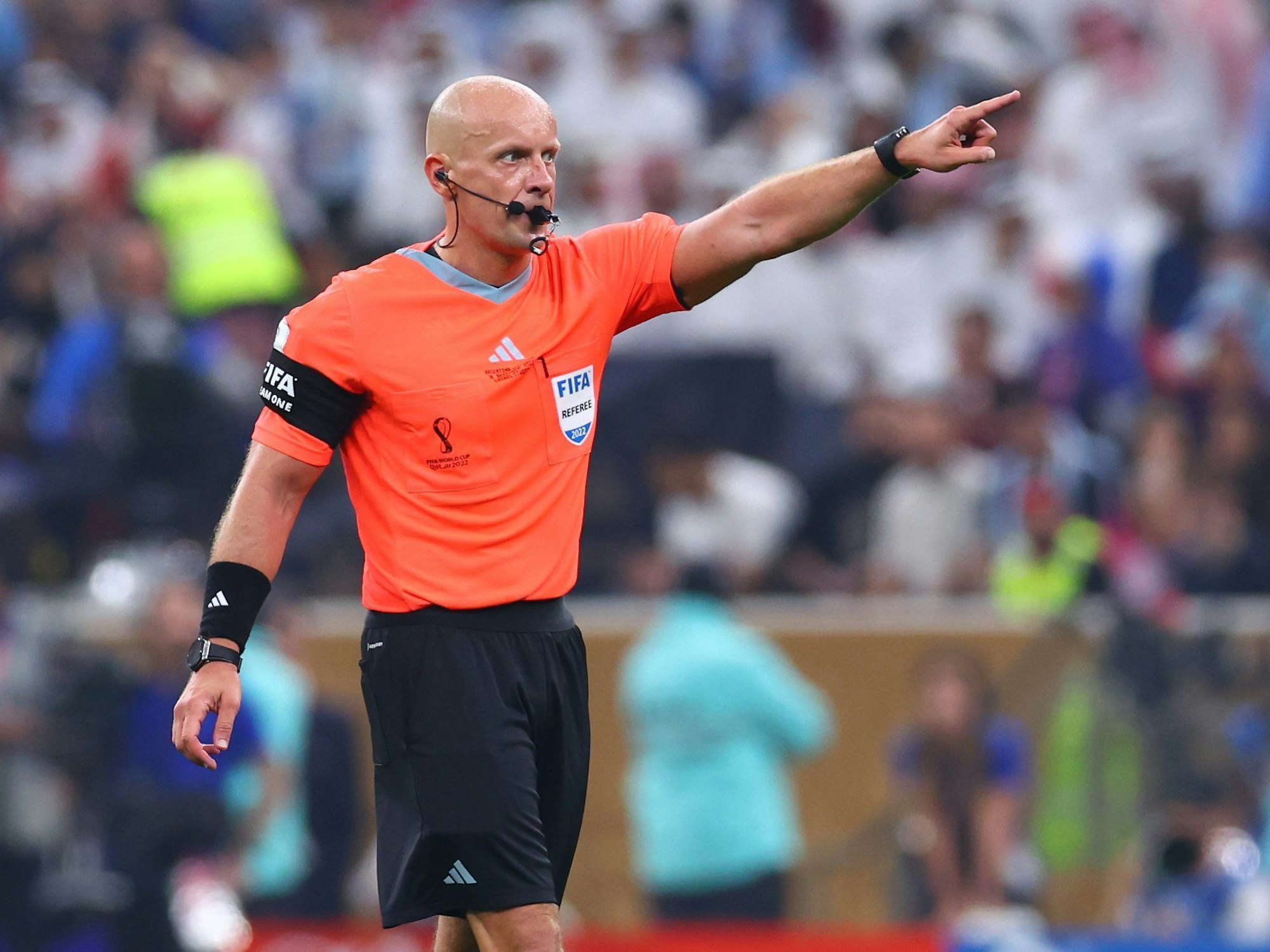 Schiedsrichter Szymon Marciniak zeigt auf dem Platz nach vorne.