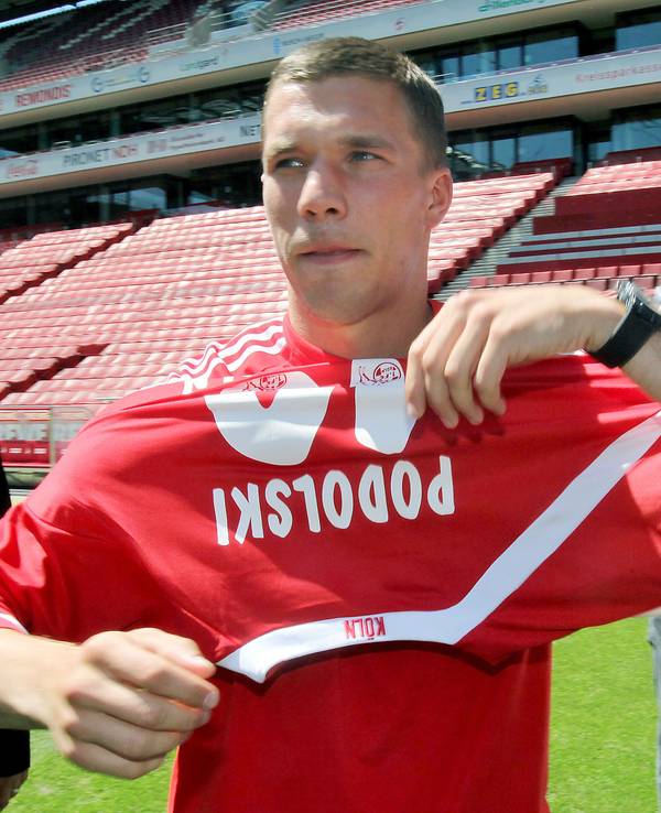 Lukas Podolski zieht sein neues FC-Trikot an.