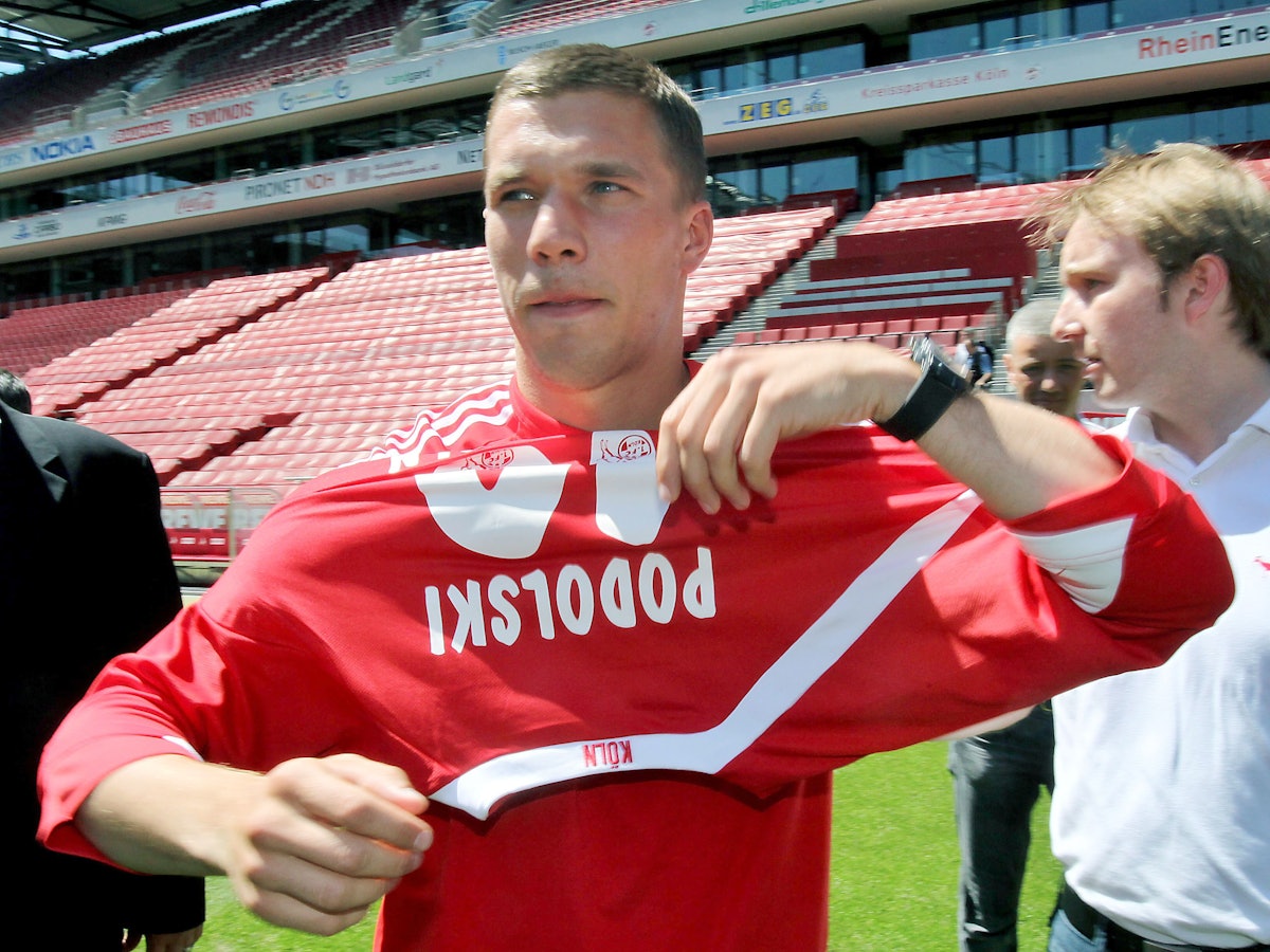 Lukas Podolski zieht sein neues FC-Trikot an.