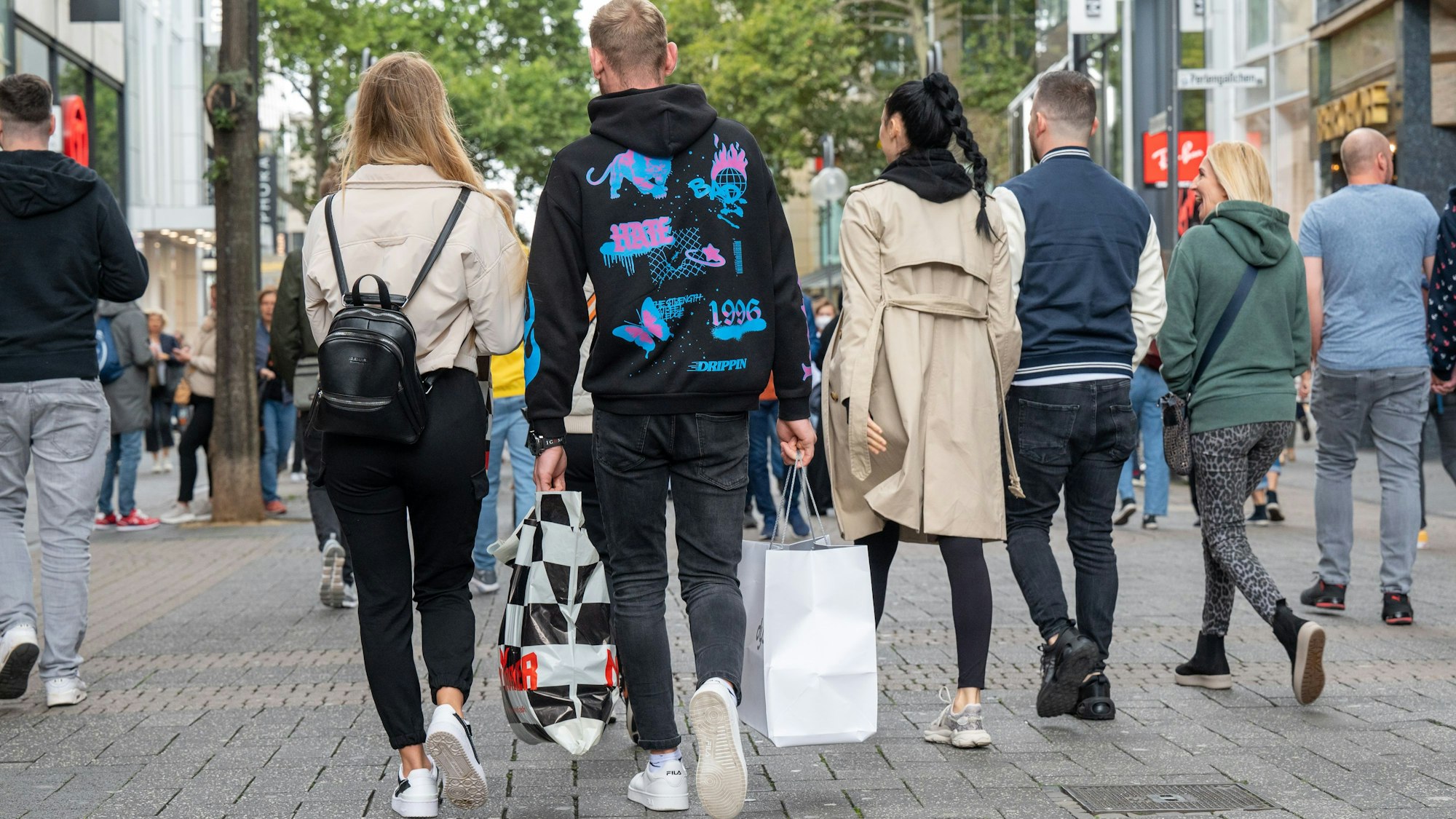 Passanten flanieren mit Einkaufstüten durch die Schildergasse.