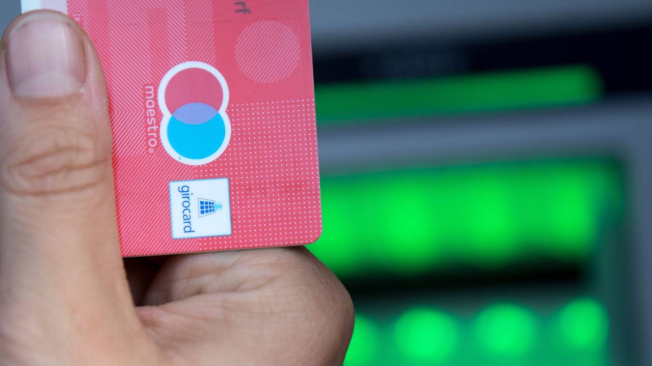 Eine Bankkundin hebt mit ihrer Girokarte Bargeld von einem Geldautomaten ab.