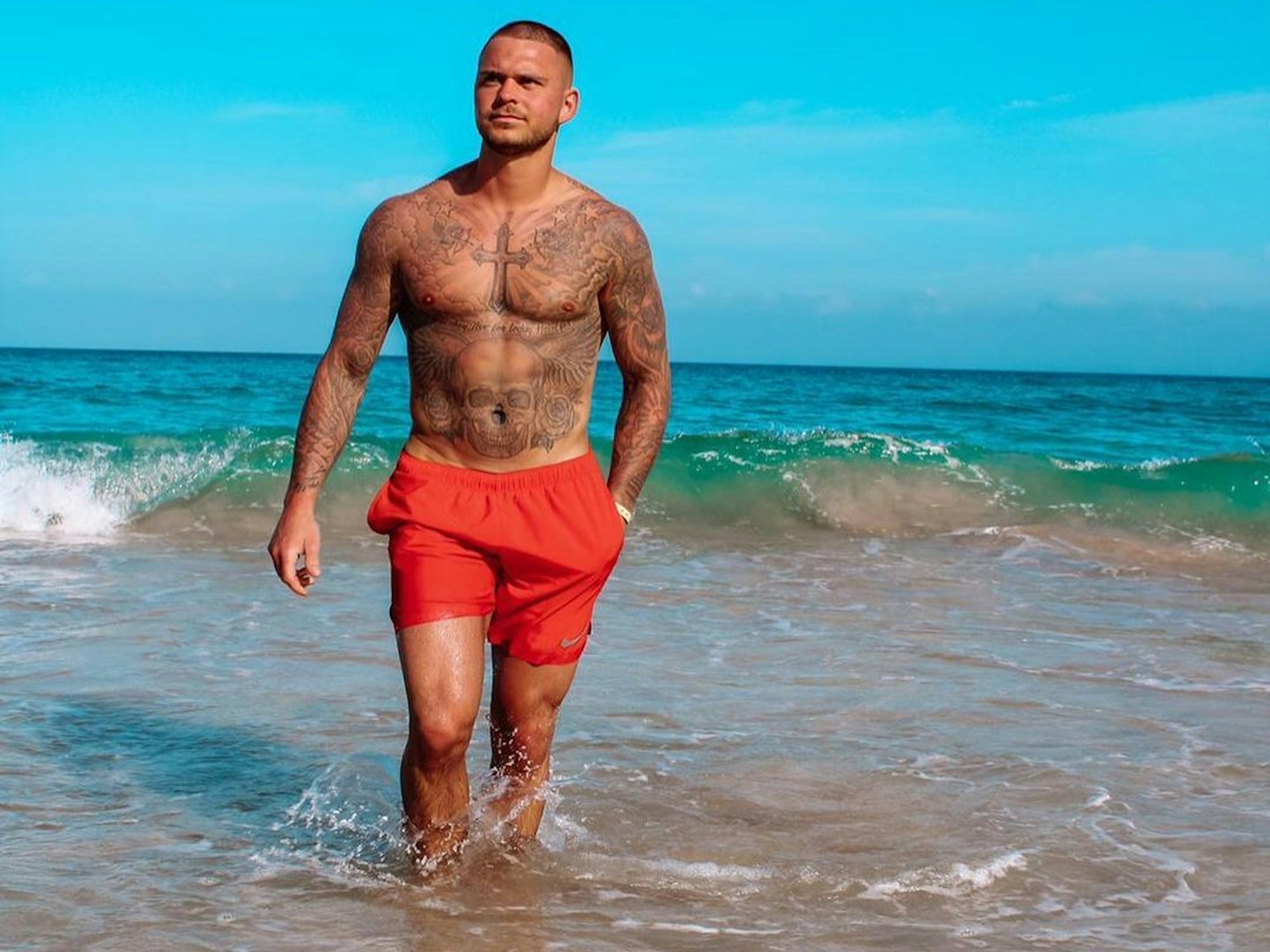 Nico Legat läuft in roter Badehose aus dem Wasser.