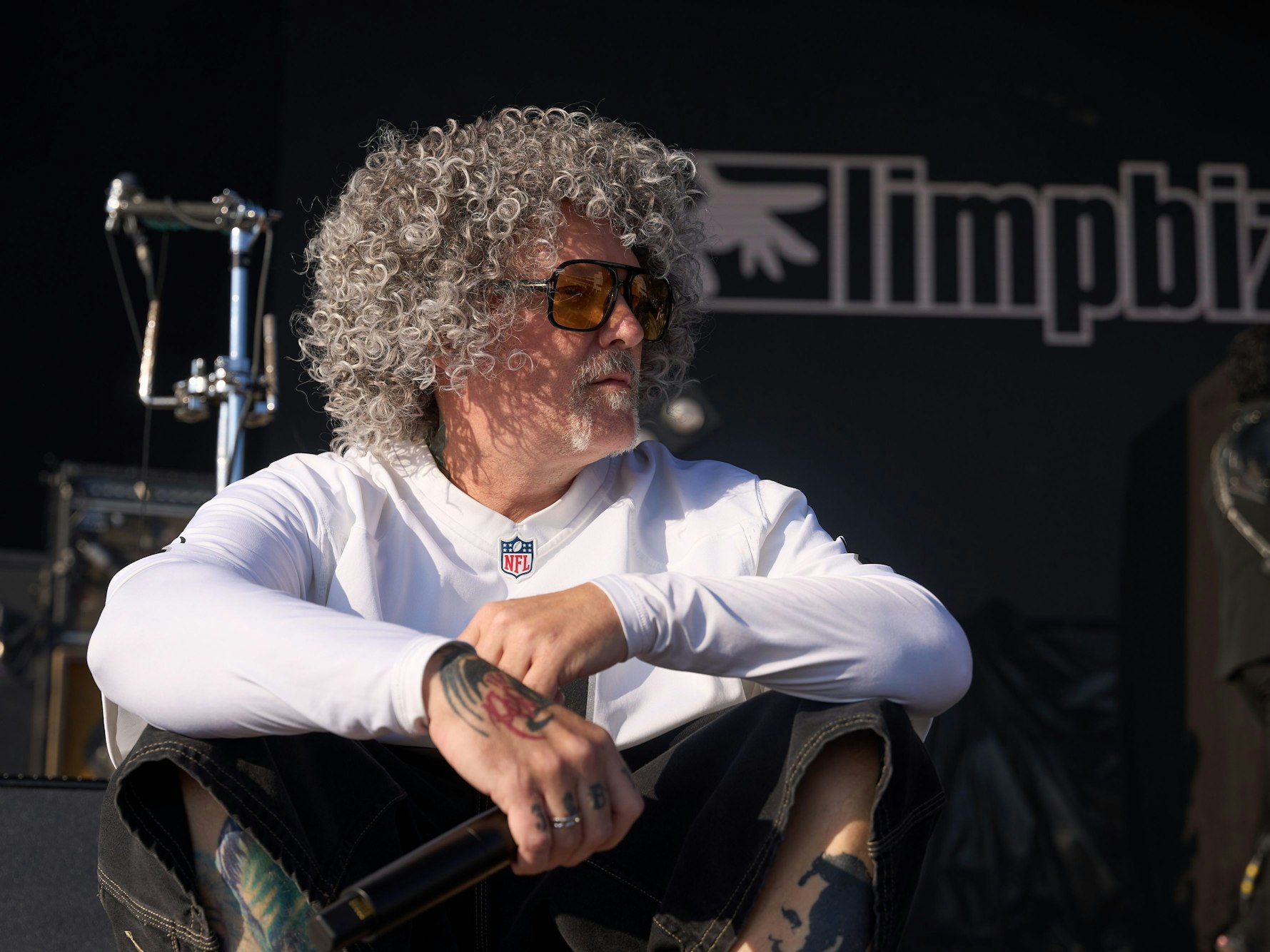 Fred Durst, Frontmann der US-Band „Limp Bizkit“ sitzt auf der Bühne.