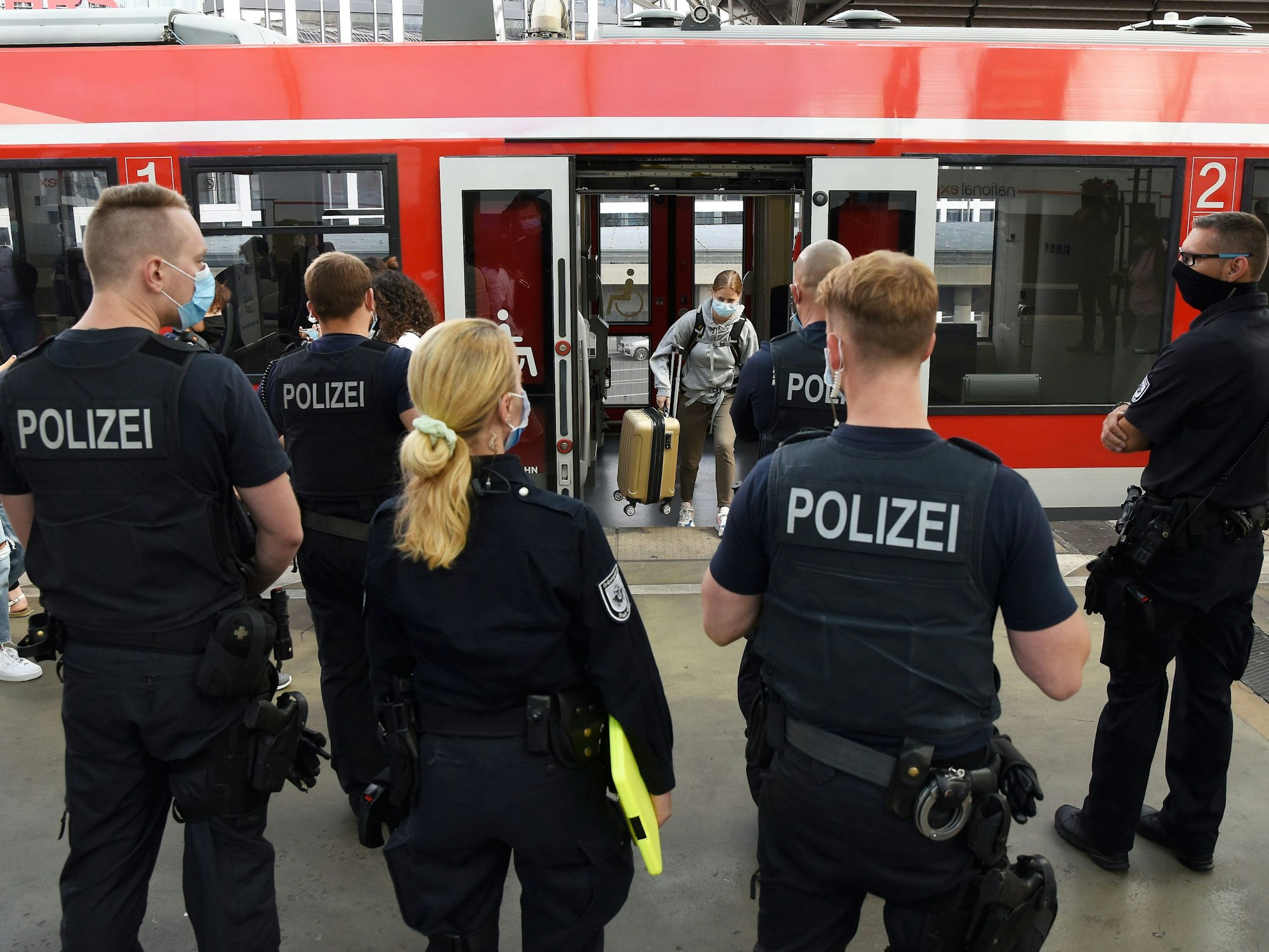 Einsatzkräfte der Polizei stehen vor einem Zug am Kölner Hauptbahnhof.