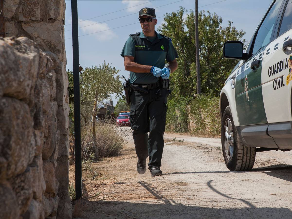 Ein Mitglied der Polizeieinheit „Guardia Civil“ geht zwischen einem Fahrzeug der „Guarda Civil“ und einer Mauer entlang.