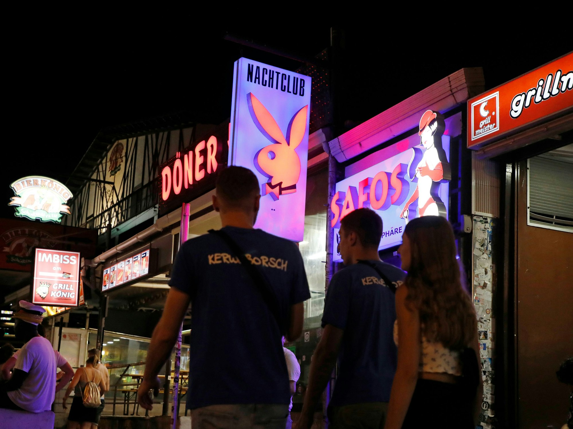 Touristen und Touristinnen laufen auf Mallorca über die Partymeile Schinkenstraße an der Playa de Palma.