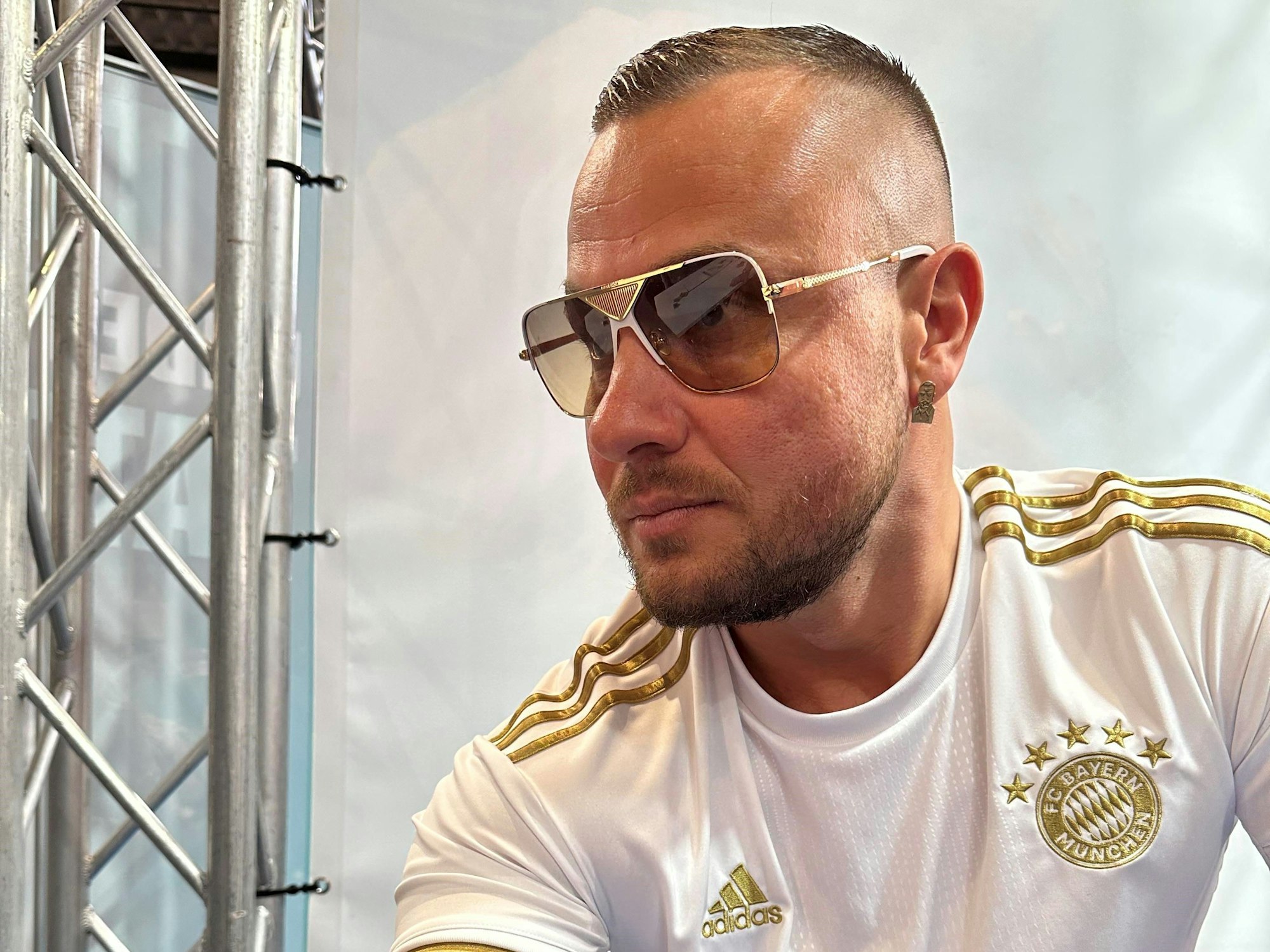 Eric Sindermann trägt eine Sonnenbrille und schaut an der Kamera vorbei.