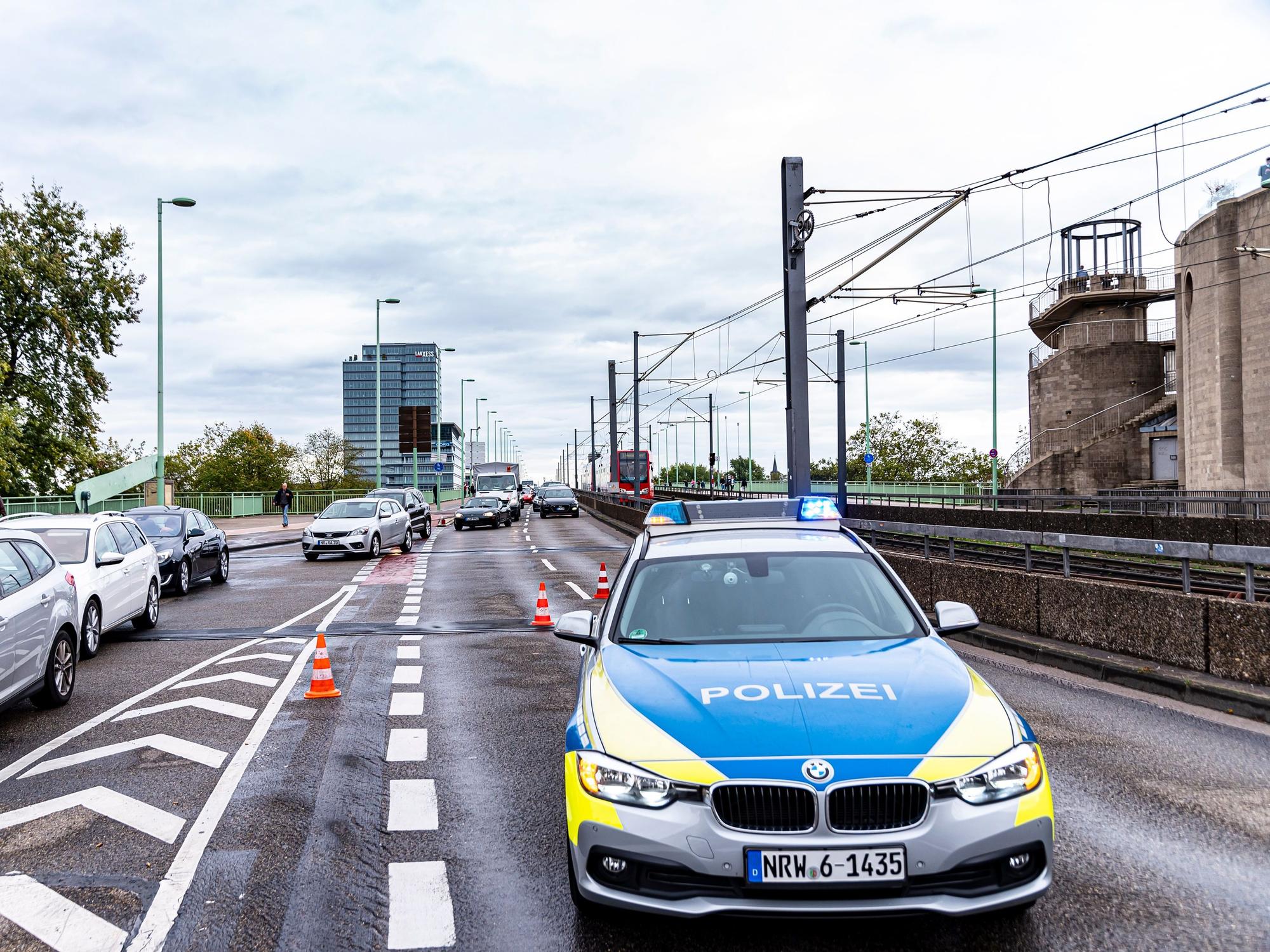 Ein Einsatzwagen der Polizei steht auf der Deutzer Brücke.