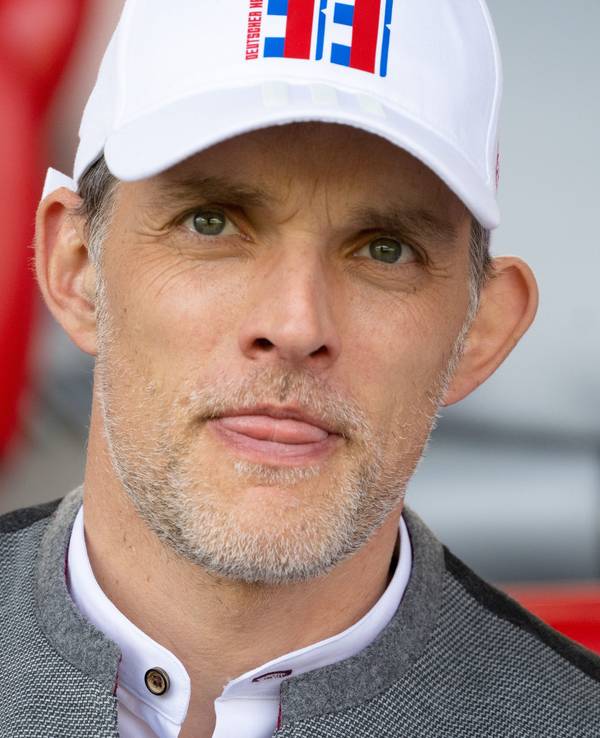 Trainer Thomas Tuchel streckt auf der Tribüne die Zunge raus.
