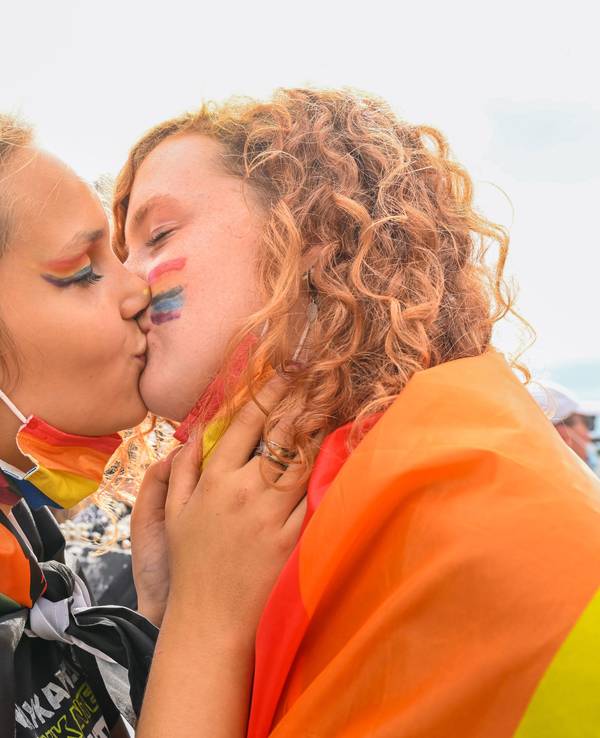 Zwei Frauen küssen sich während des Christopher Street Day 2021 in Oldenburg.