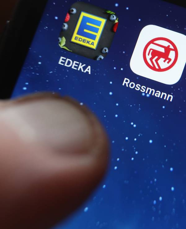 Icons der Apps von den Handelsketten Edeka, Rossmann, REWE und Kaufland sind auf dem Display eines iPhones zu sehen.