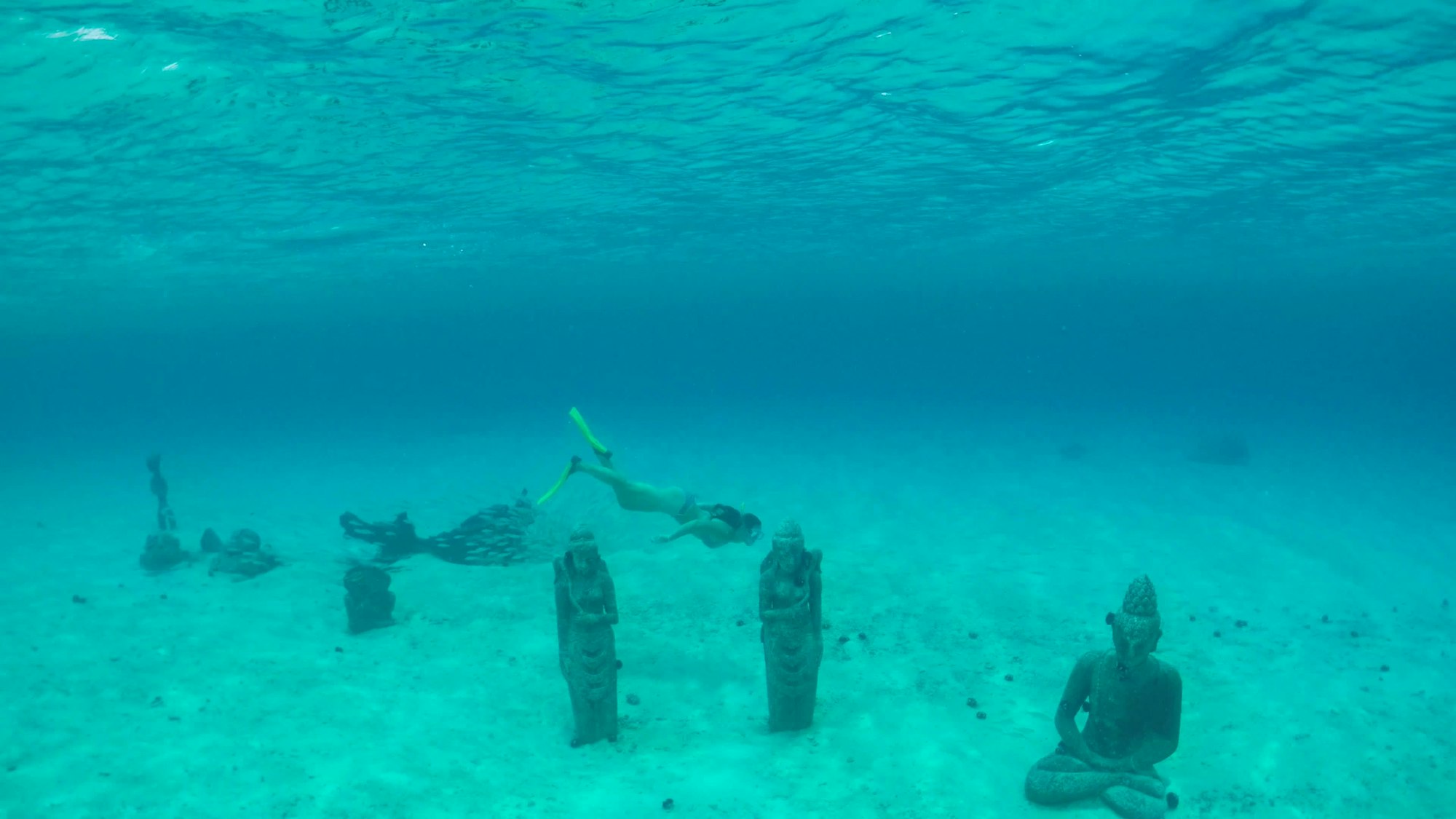 Taucherin schwimmt bei versunkenen Statuen in Bora Bora.