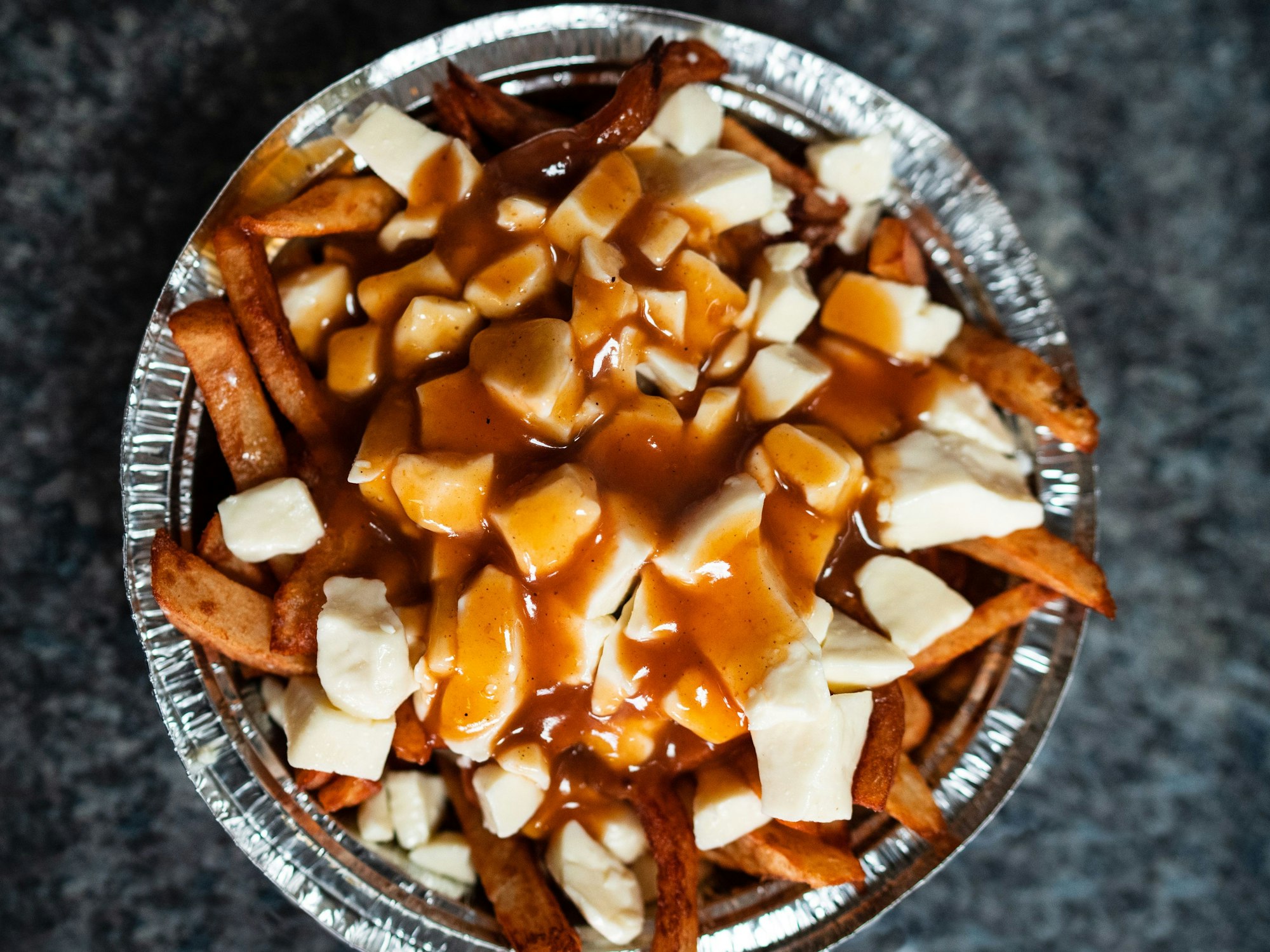 Poutine, eine typische Spezialität aus Quebec: Fritten, Bratensauce und quietschiger Käsebruch