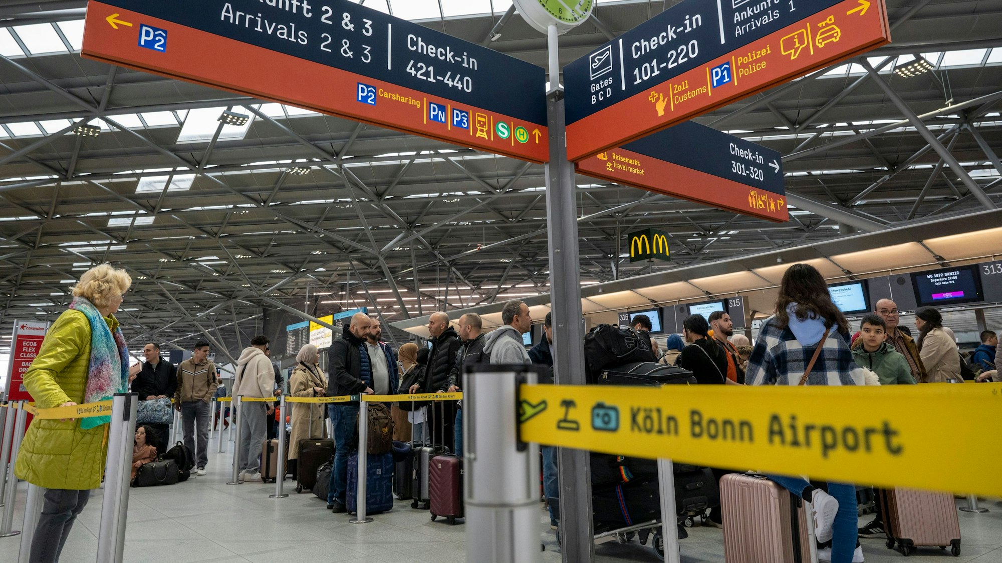 Am Flughafen checken viele Reisende zu ihrem Flug in den Urlaub ein.