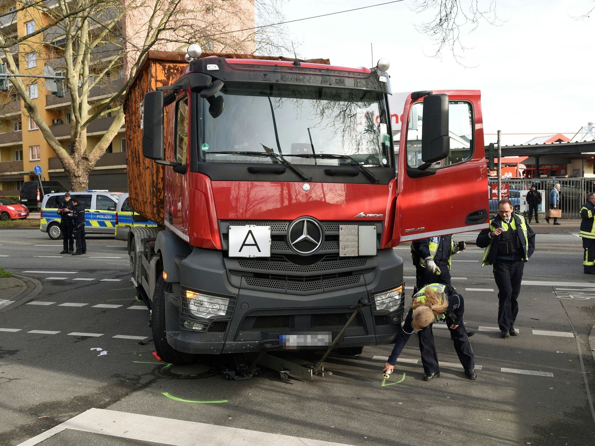 Einsatzkräfte der Polizei kennzeichnen eine Unfallstelle.