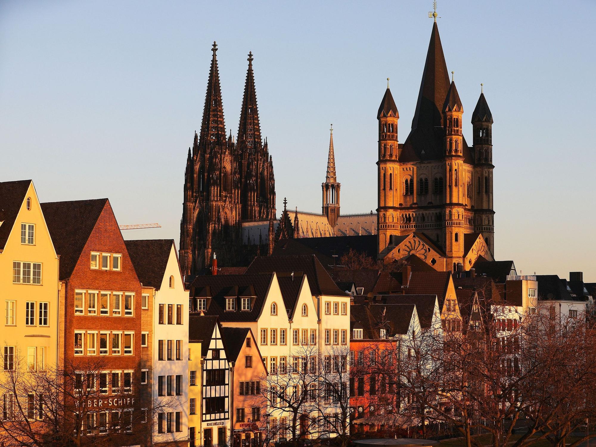 Die Sonne leuchtet am Morgen die Altstadt, den Dom (M) und die Kirche Groß St. Martin (r) an.