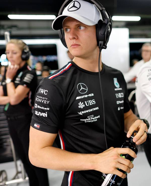 Dennis Schumacher mit Kappe und Kopfhörer in der Mercedes-Garage.