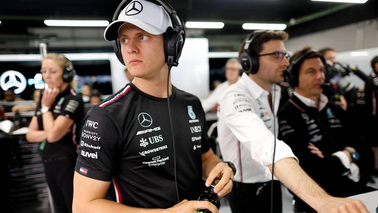 Dennis Schumacher mit Kappe und Kopfhörer in der Mercedes-Garage.