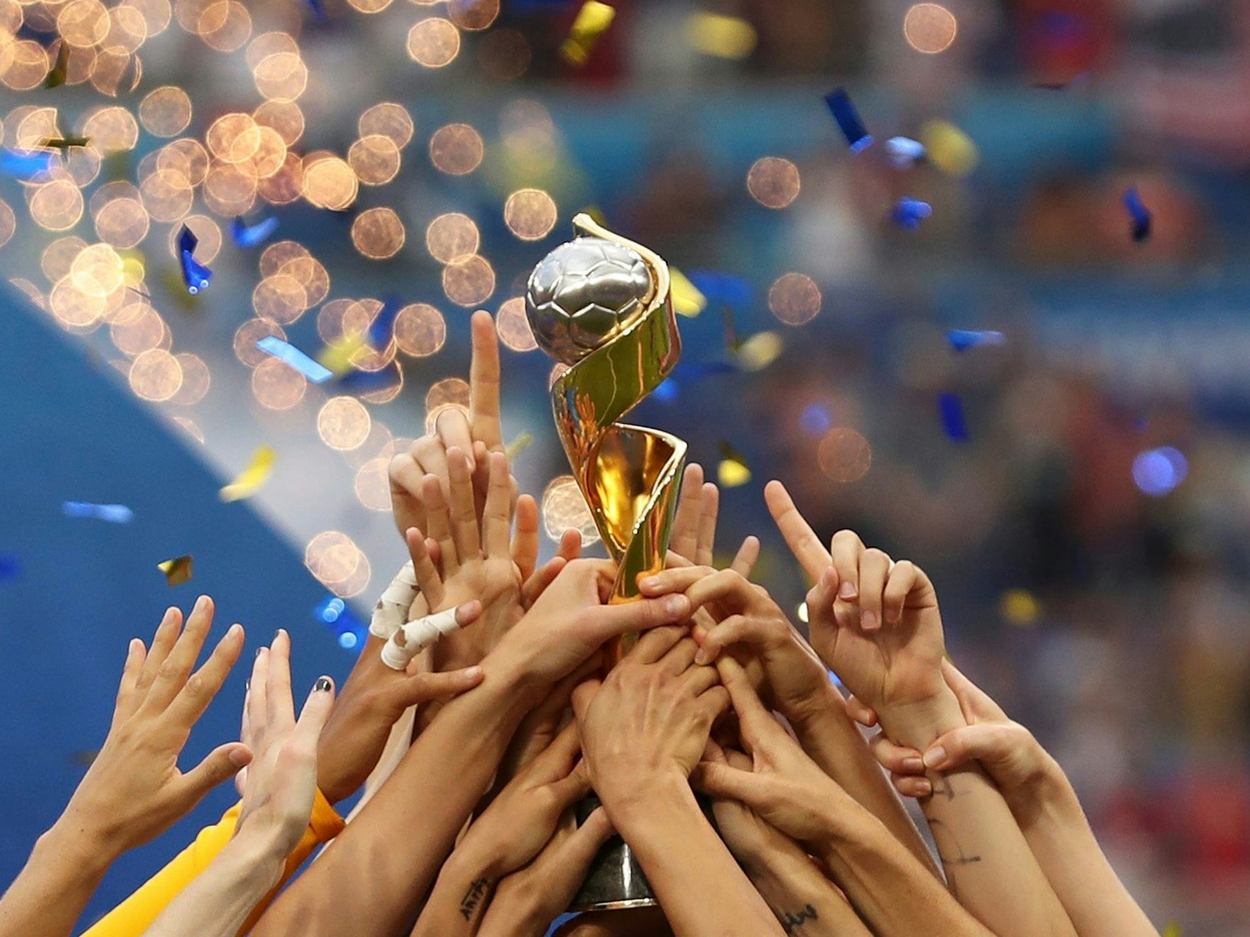Spielerinnen des US-Teams halten gemeinsam die Trophäe.