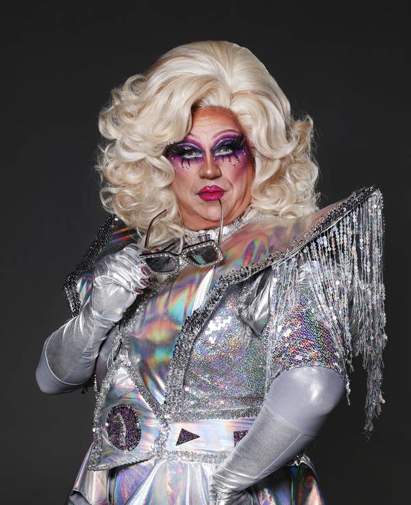 Dragqueen Sylvia Stoned hat eine Sonnenbrille im Mund.