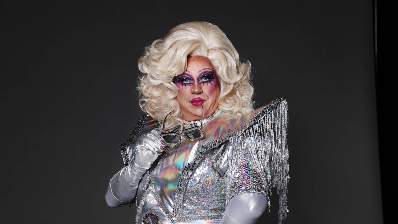 Dragqueen Sylvia Stoned hat eine Sonnenbrille im Mund.