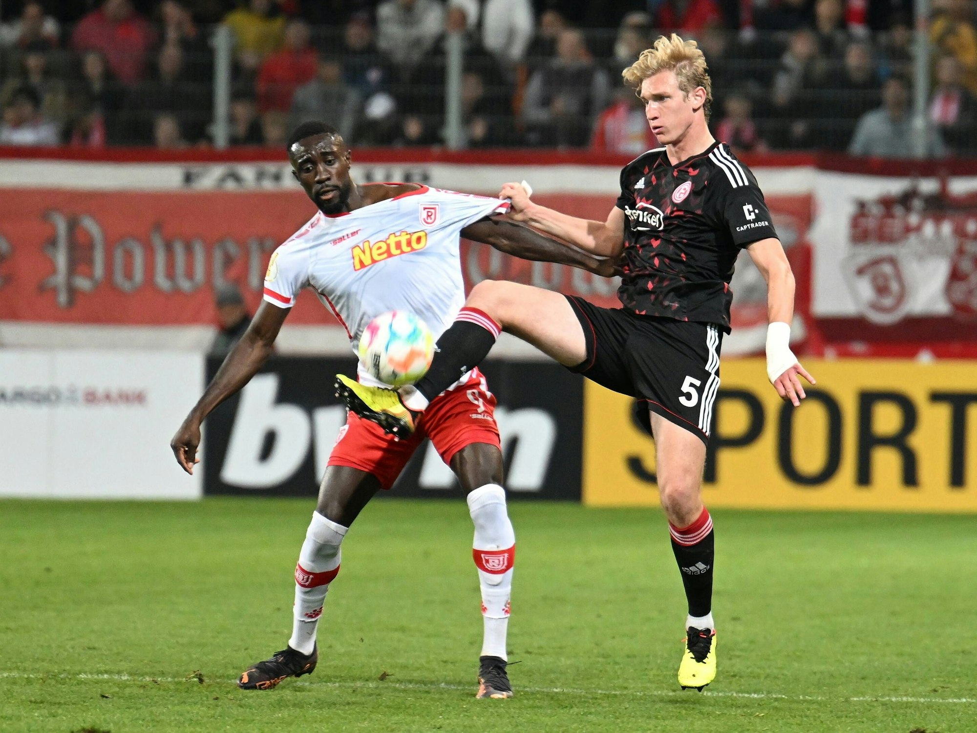 Prince Osei Owusu (Regensburg) kämpft mit Christoph Klarer (Fortuna Düsseldorf) um den Ball.