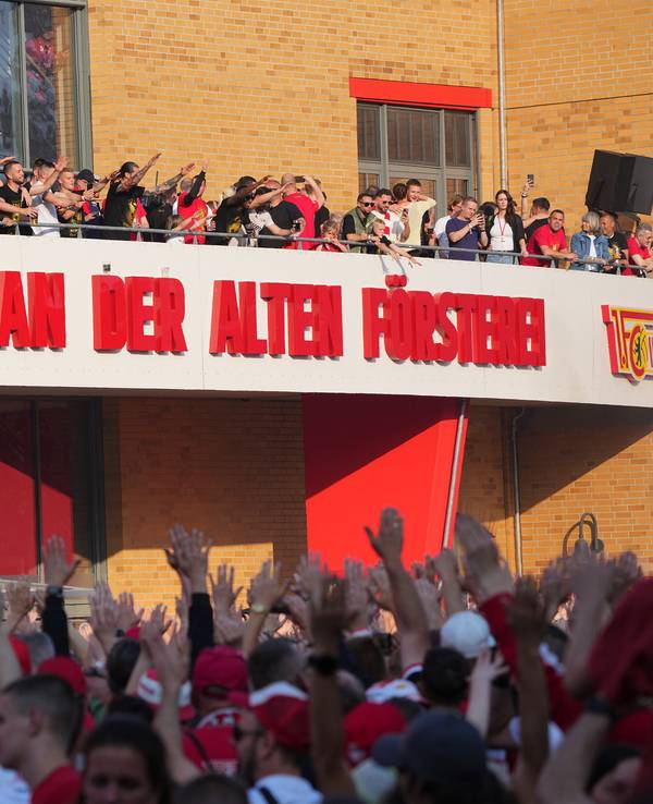 Unions Spieler und Fans feiern vor dem Stadion-Eingang.