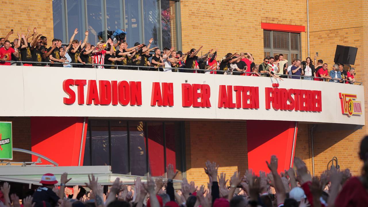 Unions Spieler und Fans feiern vor dem Stadion-Eingang.
