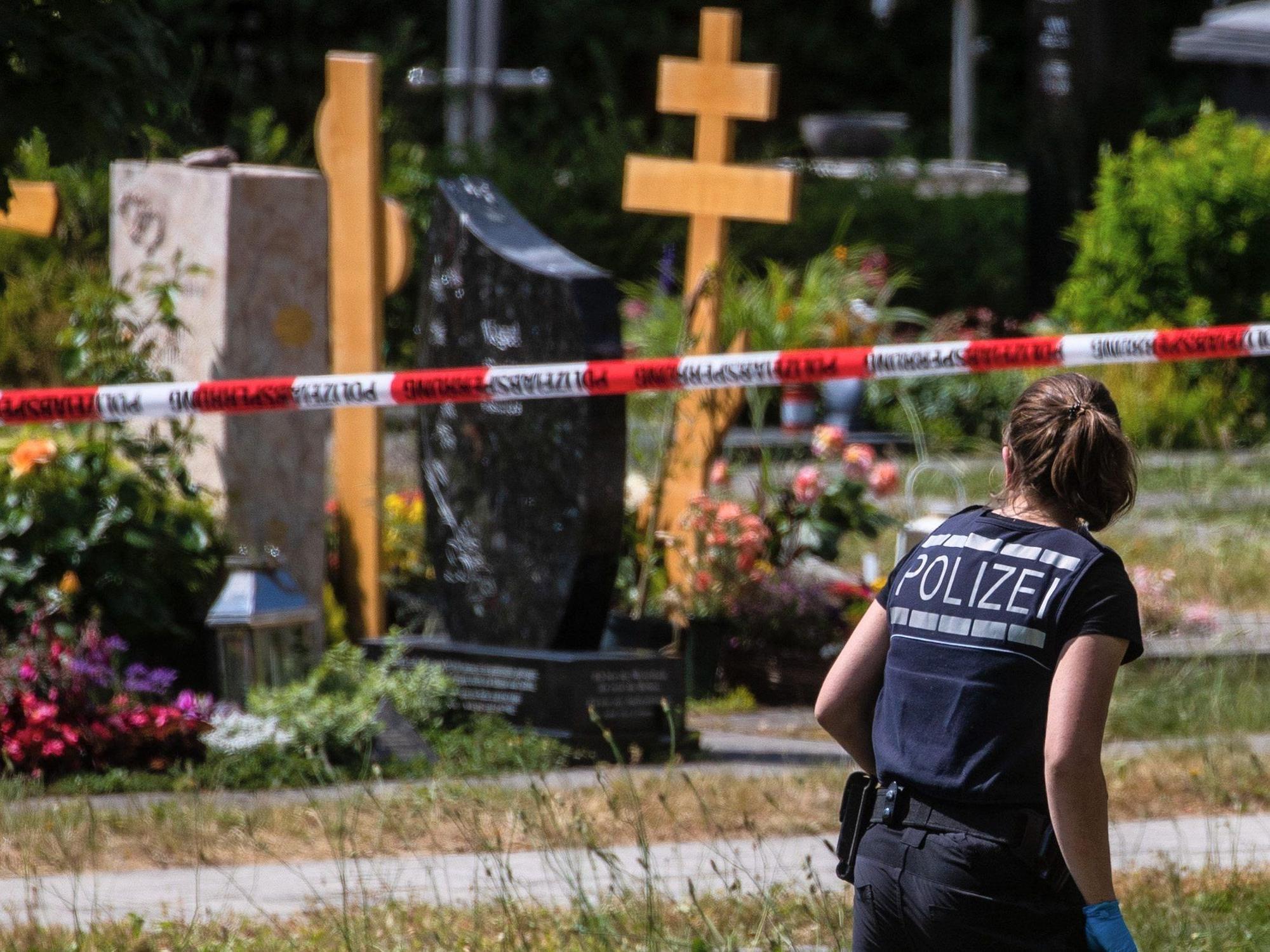 Altbach: Eine Polizistin geht über den abgesperrten Teil an einem Tatort auf einem Friedhof.