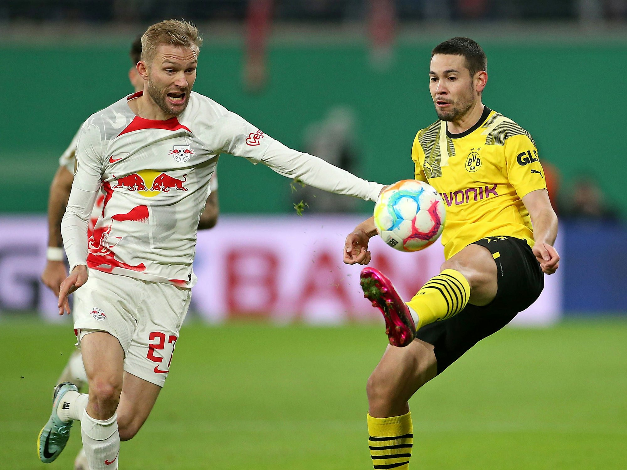Konrad Laimer von Leipzig versucht an den Ball zu kommen. Raphael Guerreiro kickt den Ball in die Luft, um Laimer auszuspielen.