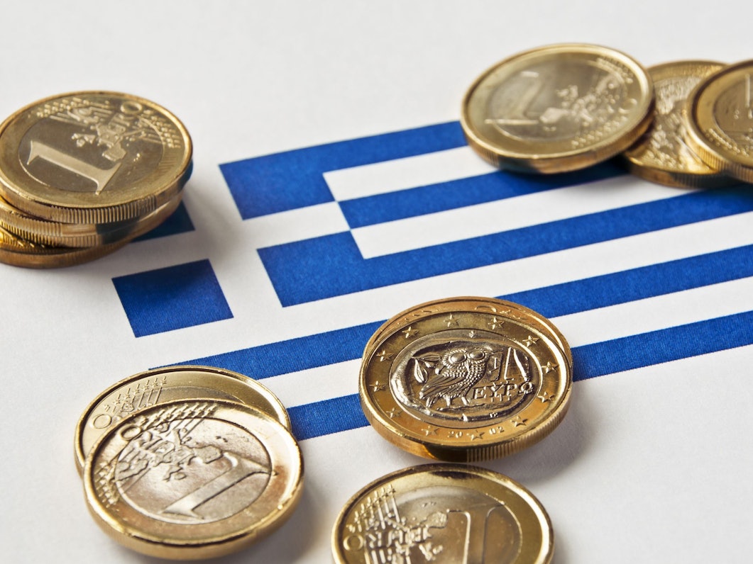 Trinkgeld liegt auf einer Griechenlandflagge.